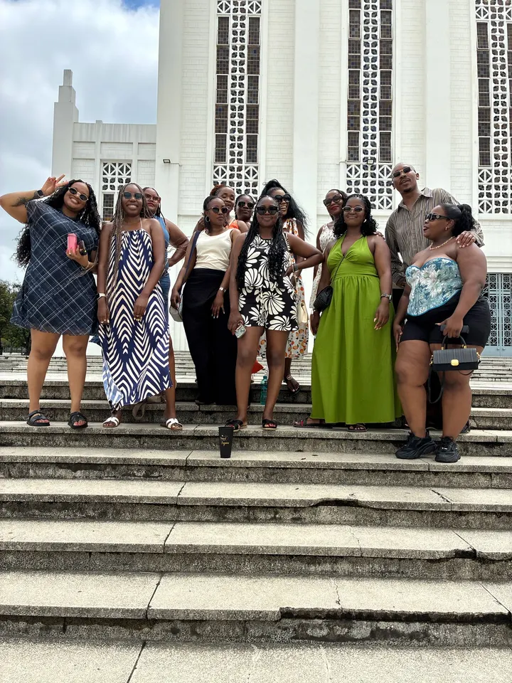 A tour group on the steps of a white building in Mozambique