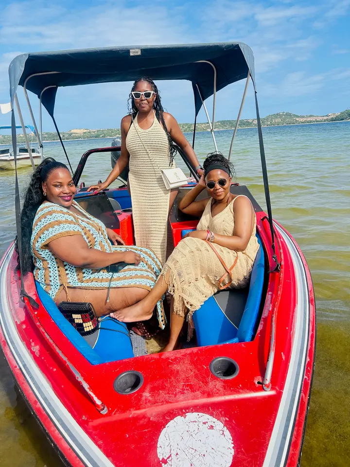 Three women in a red speedboat on a lagoon
